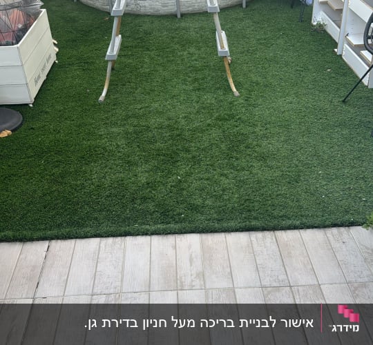 בריכה עגולה עם סולם על דשא סינתטי